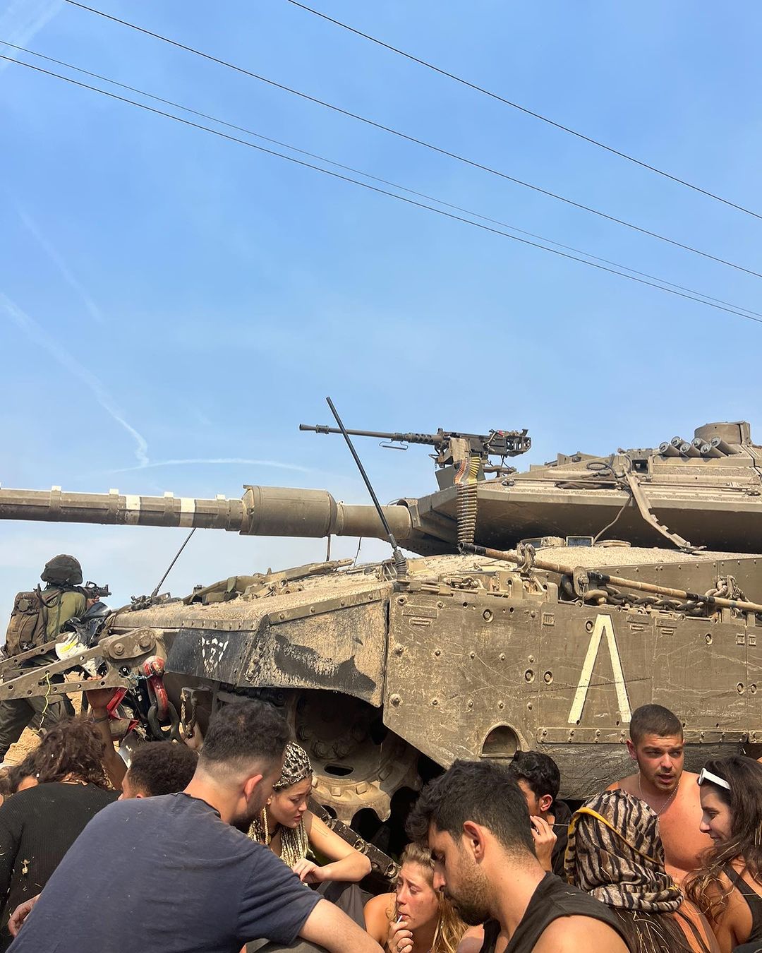 A tank and people are hiding next to it