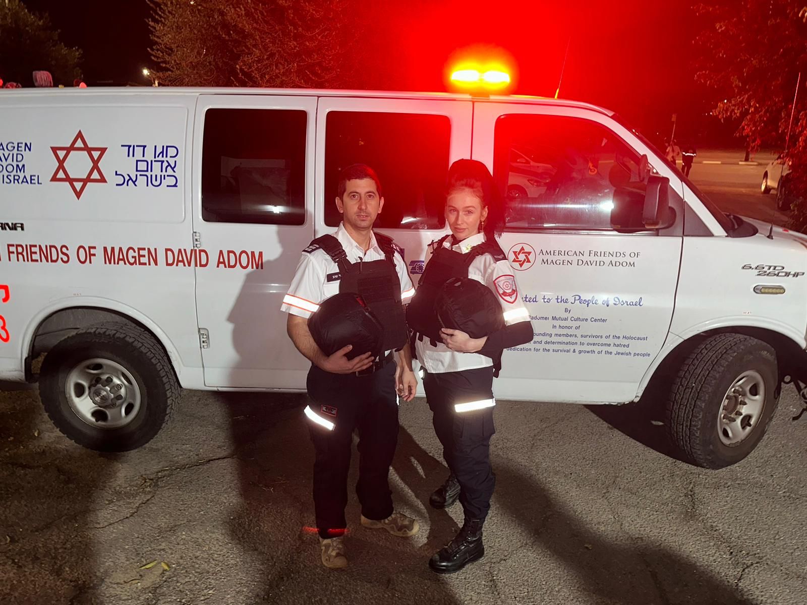 A married couple volunteering at the MDA next to an ambulance