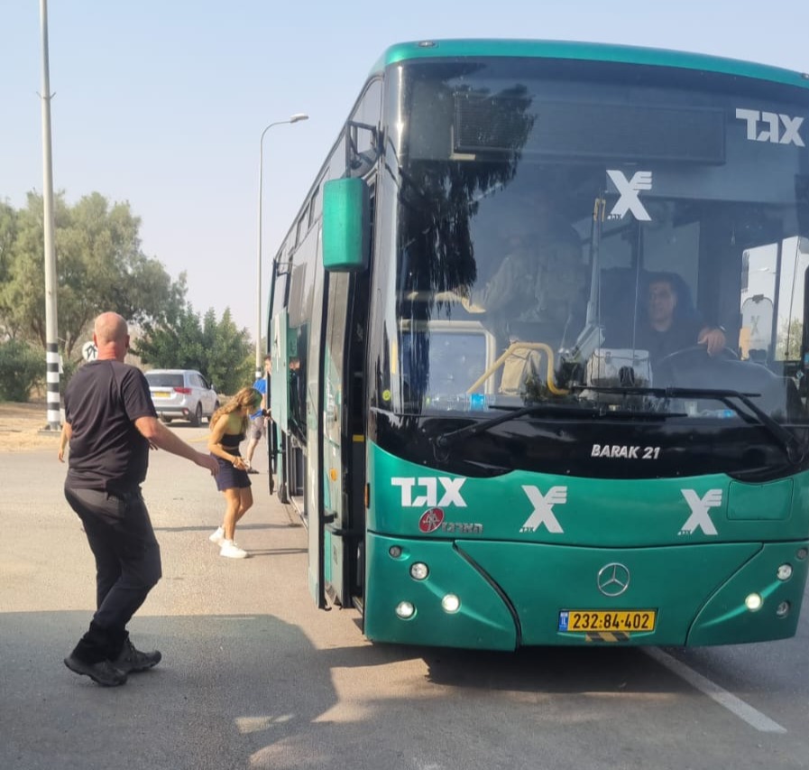 Two people are standing at the entrance of an Egged company busTwo people are standing at the entrance of an Egged company bus