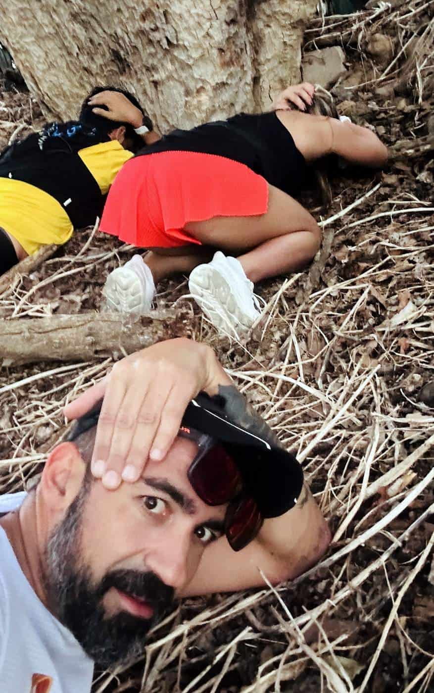 Naomi, Kobi and Ram laying on the ground during a missile attack