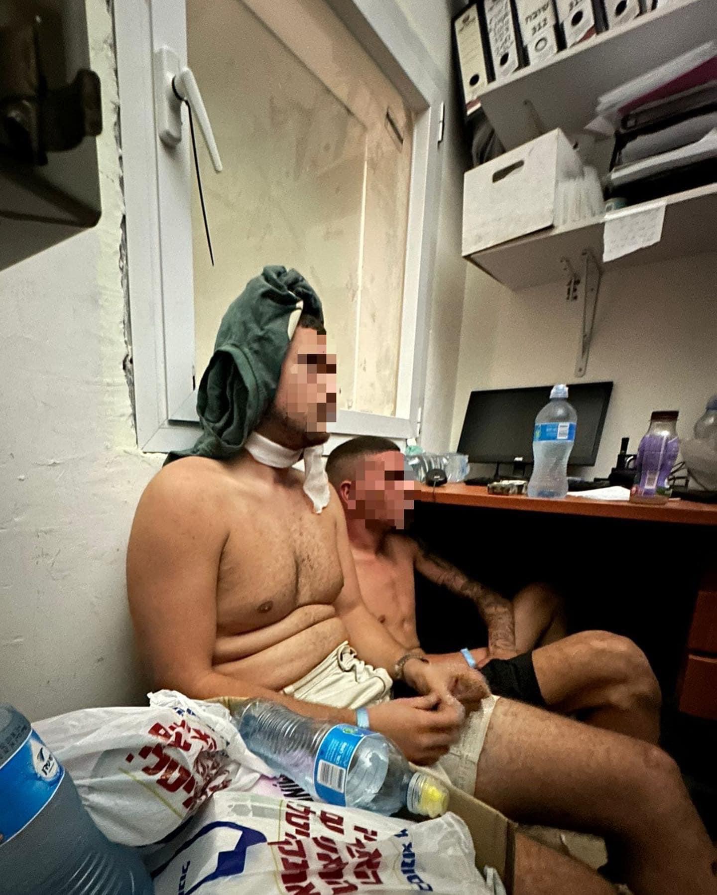 Two men are sitting in a room without shirts and faces are blurred