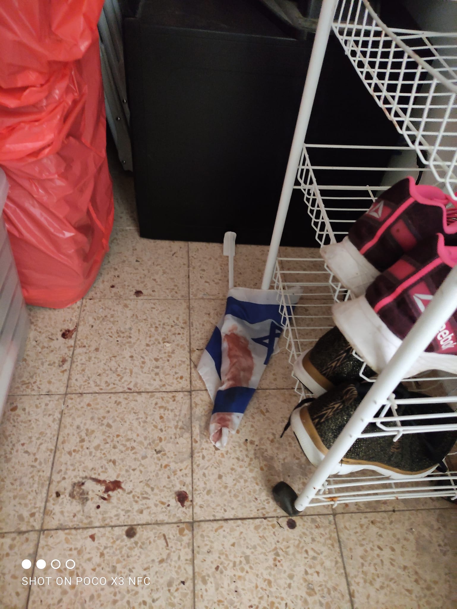 The Israeli flag is thrown on the floor and covered in blood
