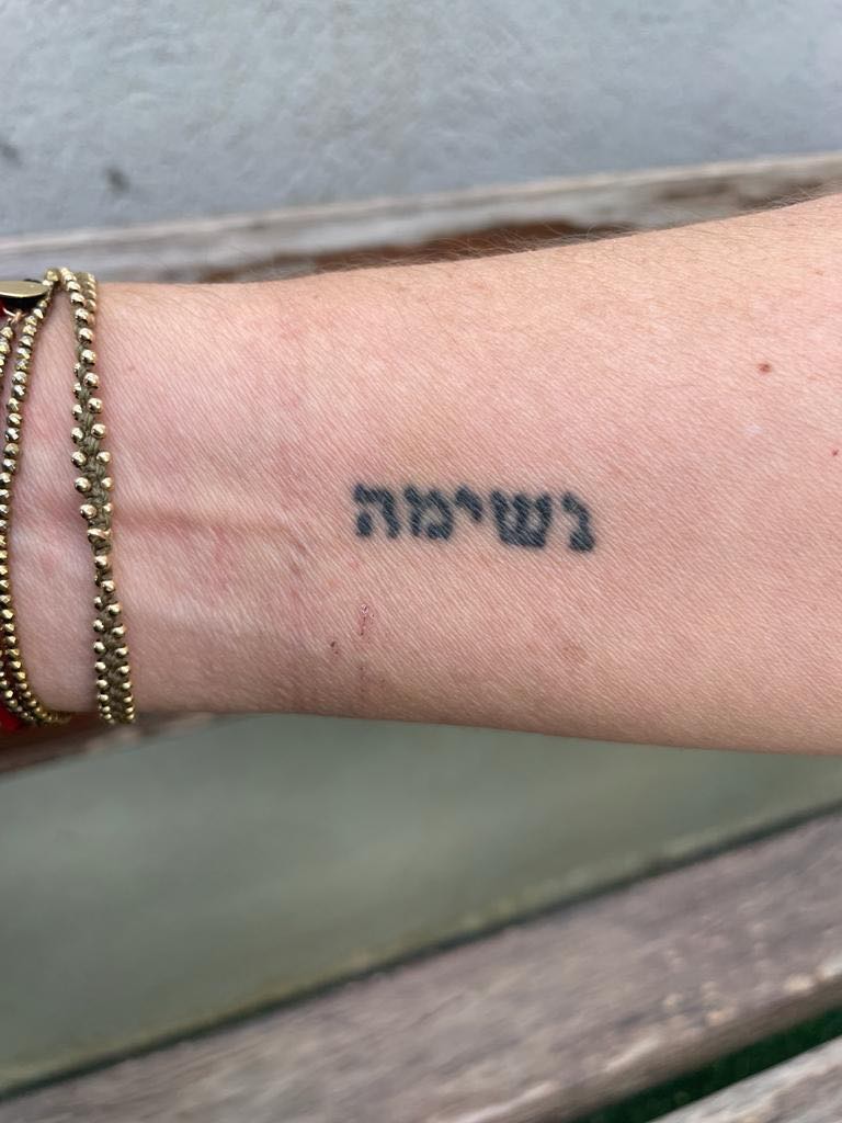 A hand with a tattoo that says "breath"