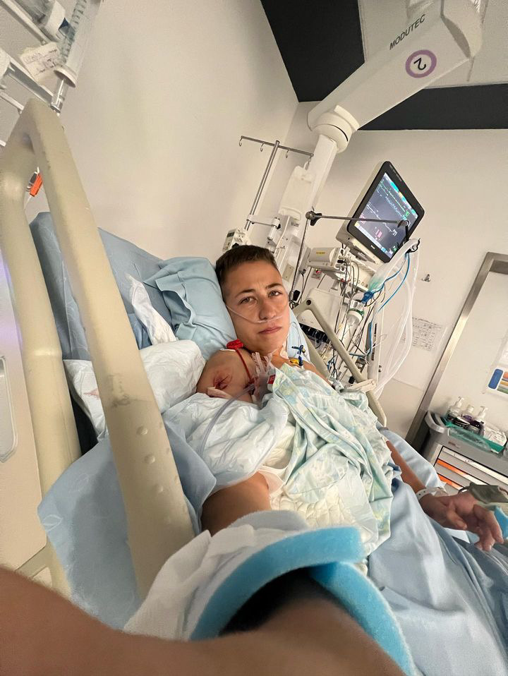 Naama on a hospital bed with a gunshot wound on her shoulder