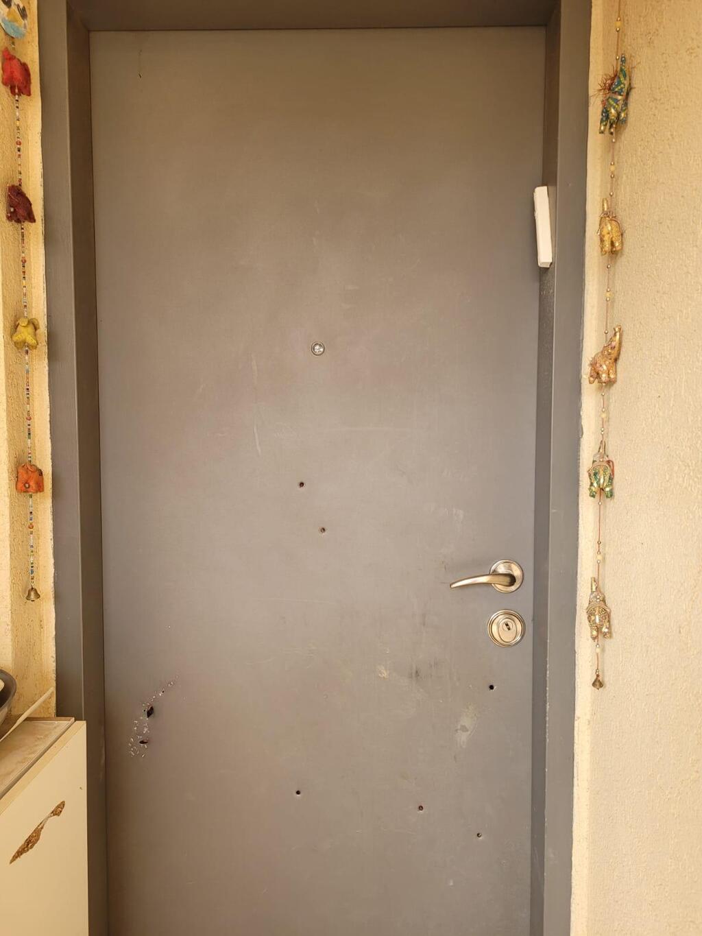The door of Dorin's family's home - filled with bullet holes