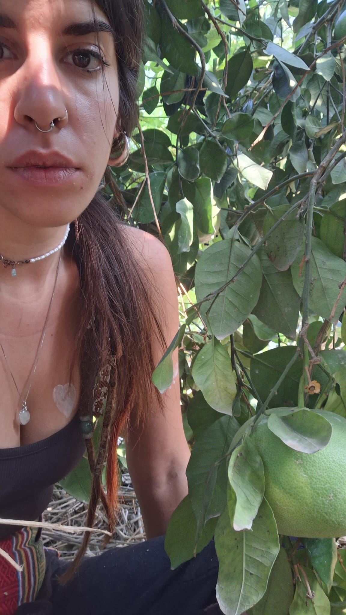 Liron E. is sitting on the ground among leaves