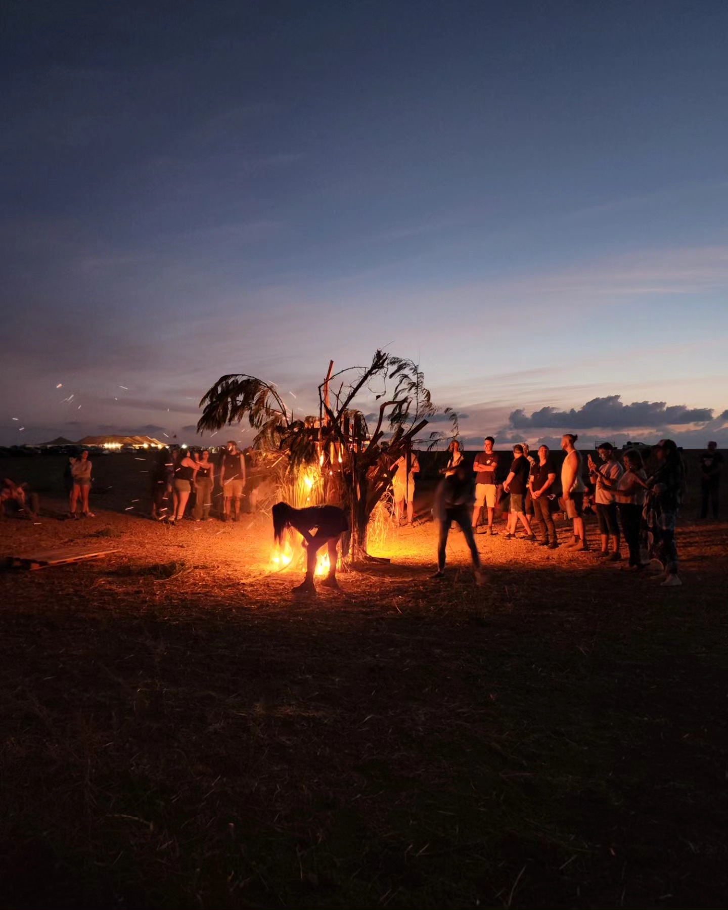 People stand around the fire