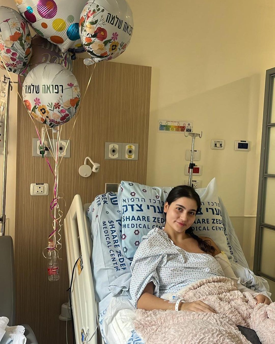 Eden is sitting on a Shaare Zedek hospital bed