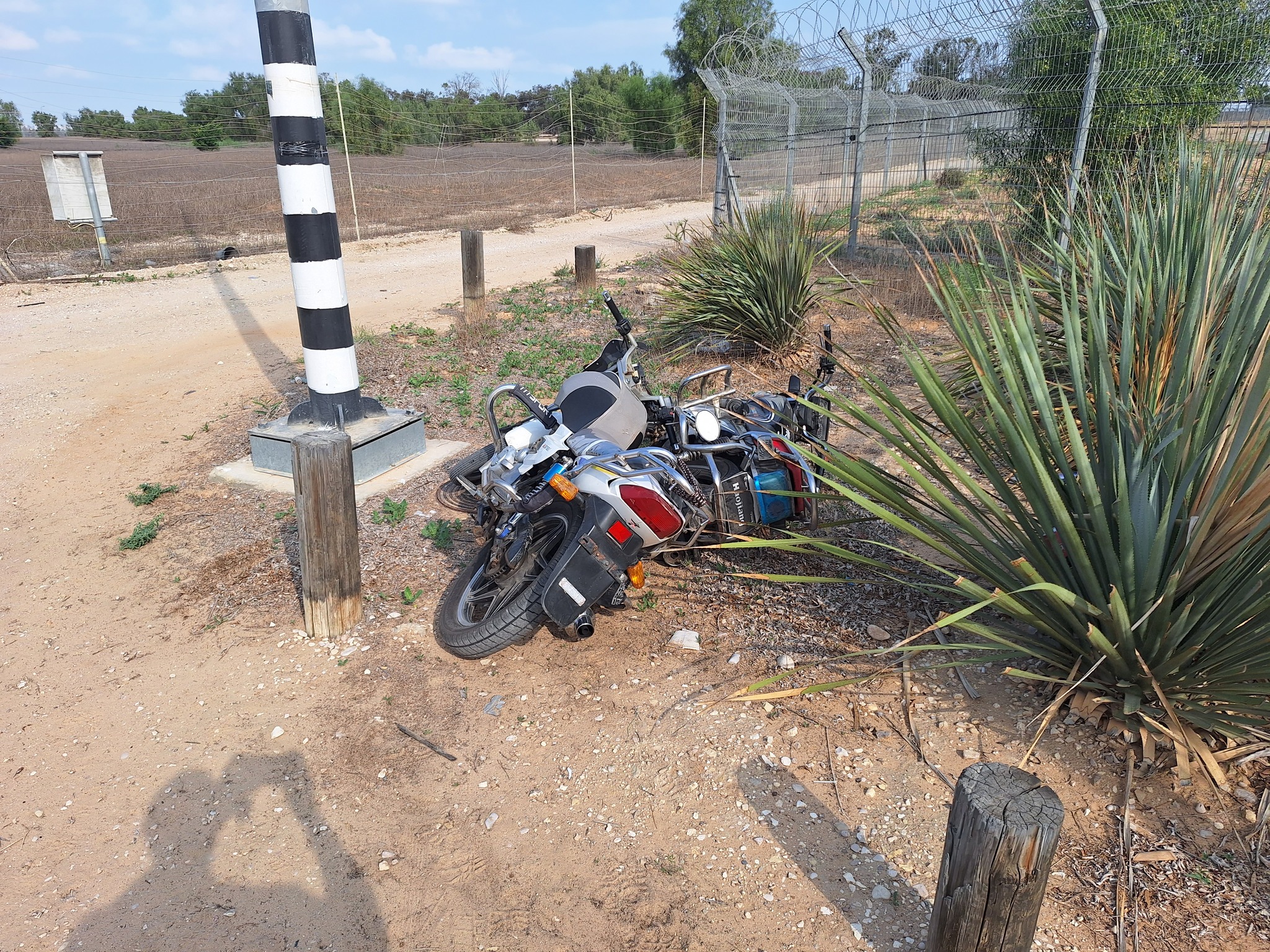 Two motorcycles are left on the side of the road