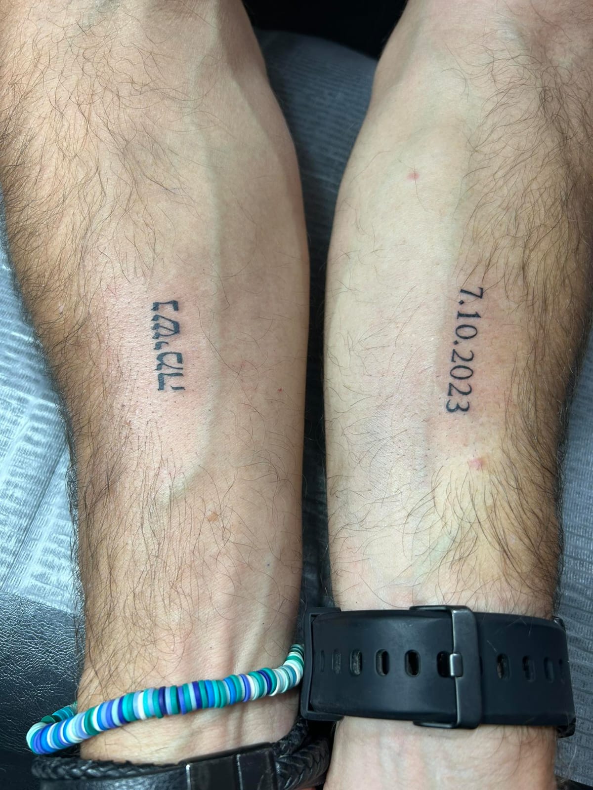 Two hands in each hand a different tattoo. One says breath. On the other hand the date of October 7