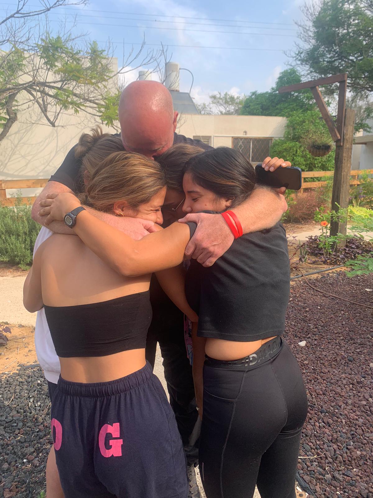 A man hugs four women