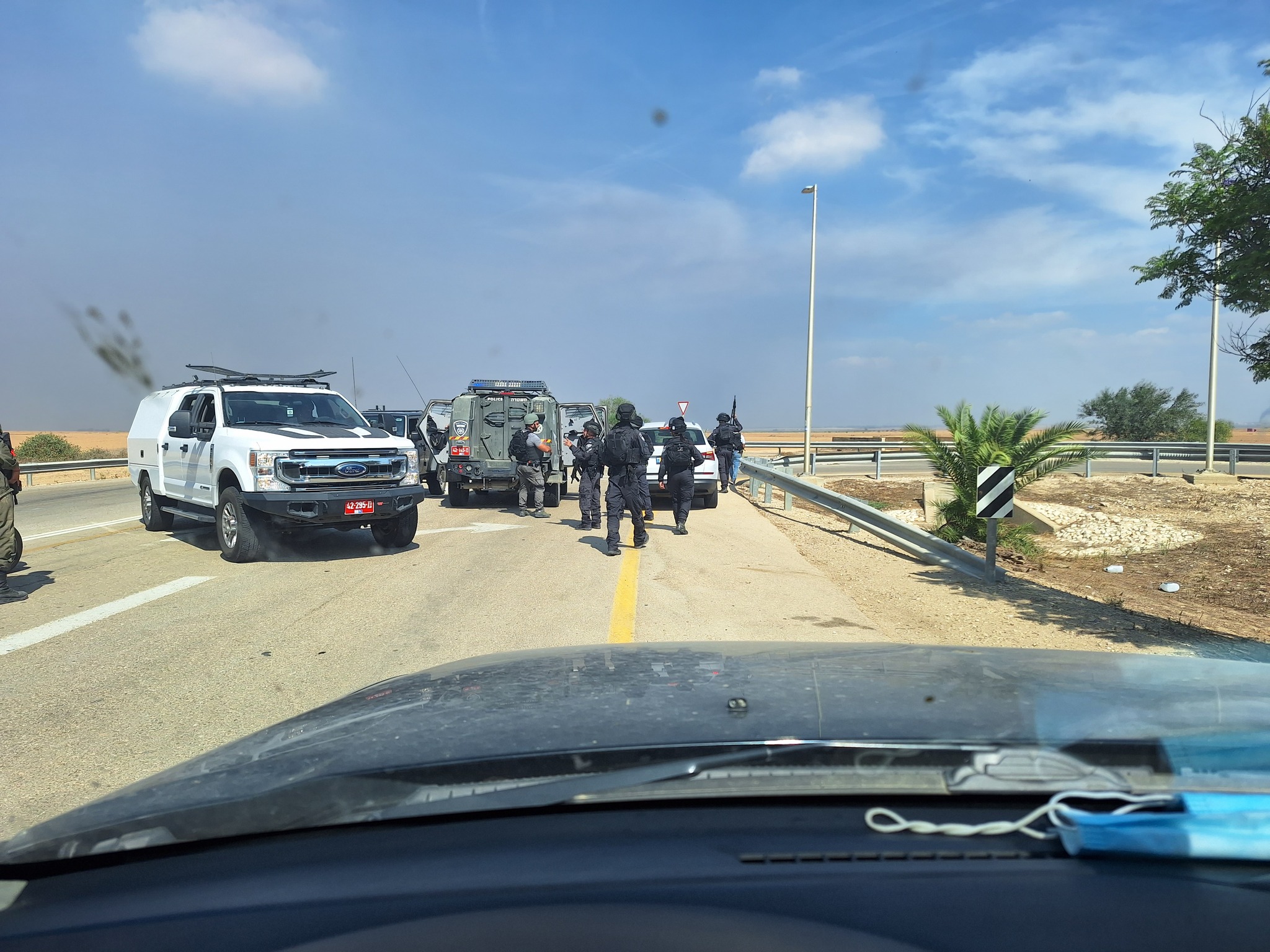 Military policemen with vehicles are standing and preventing access to the road